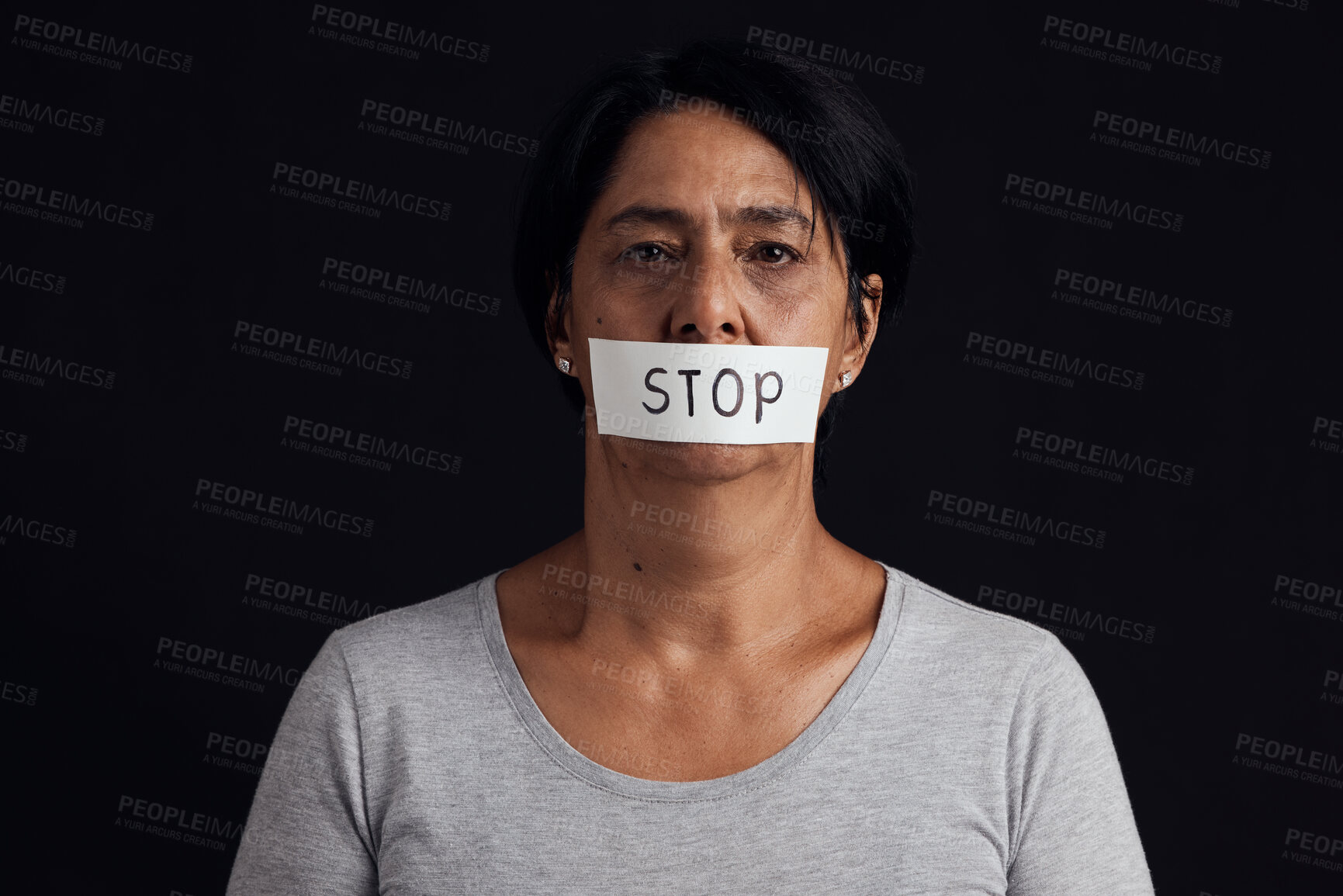 Buy stock photo Portrait, stop and censorship with a woman in studio on a black background for gender equality or domestic violence. Face, silence or abuse and a scared female victim with her mouth covered in fear