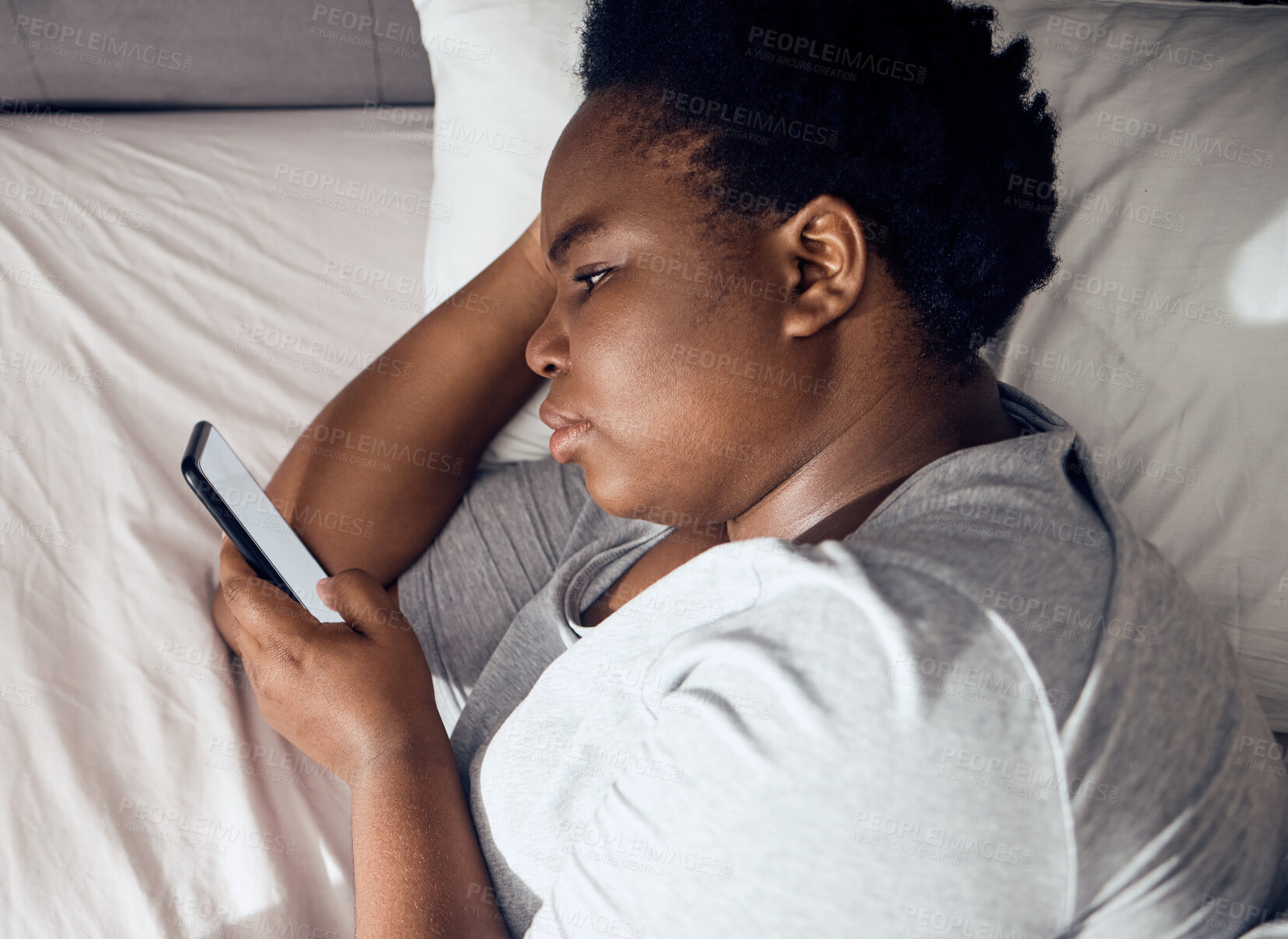 Buy stock photo Stress, morning or black woman in bed with phone for social media lying in room for addiction at home. Insomnia, lonely or sad person reading online to scroll on mobile app in bedroom with depression