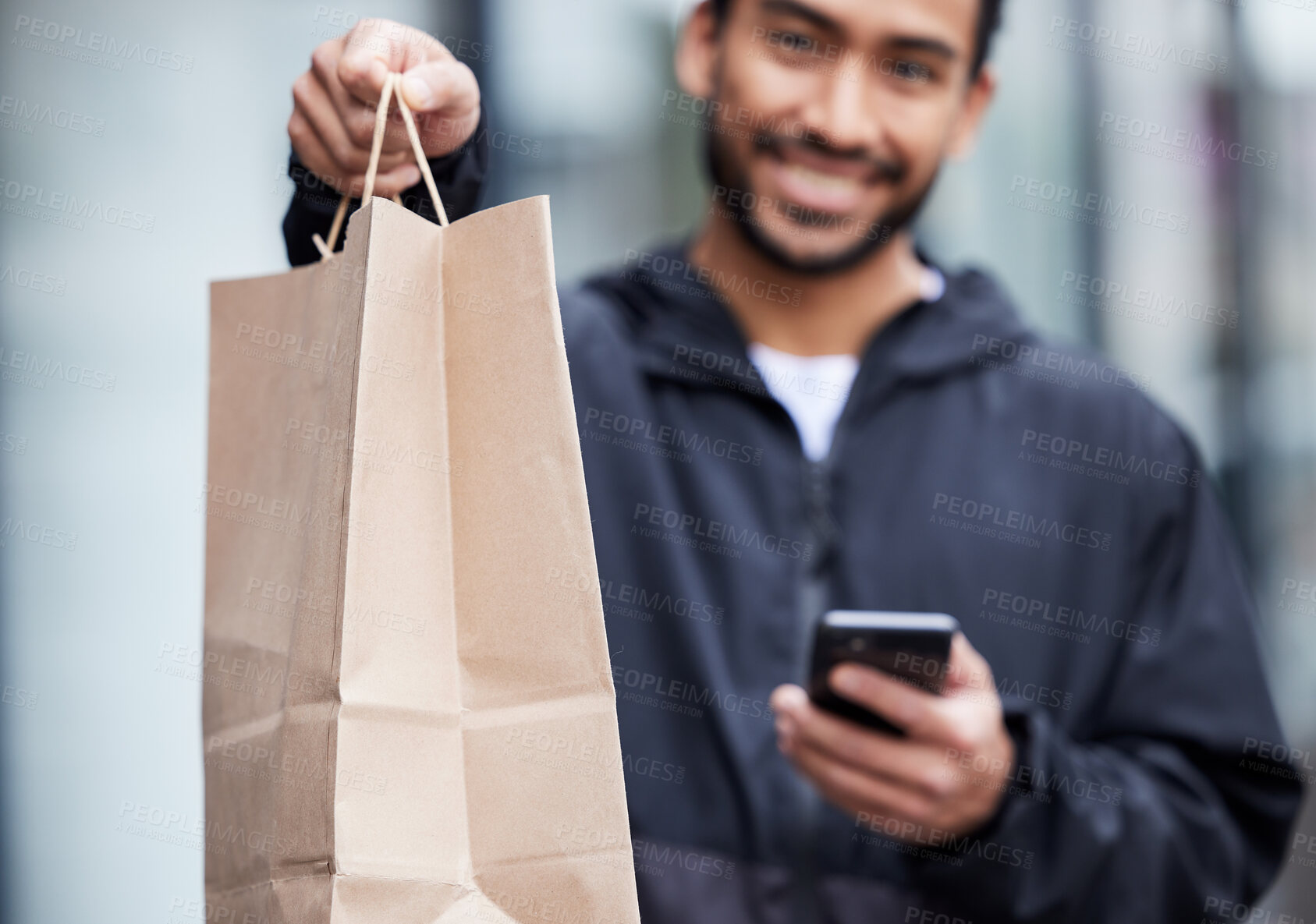 Buy stock photo Courier man, giving paper bag and portrait with phone, smile and delivery service in supply chain job. Young logistics worker, package and hand with smartphone, product and e commerce in metro cbd