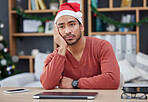 Bored, christmas hat and exhausted man in the office while working on a creative project. Tired, burnout and young professional male designer with xmas decorations working in the modern workplace.