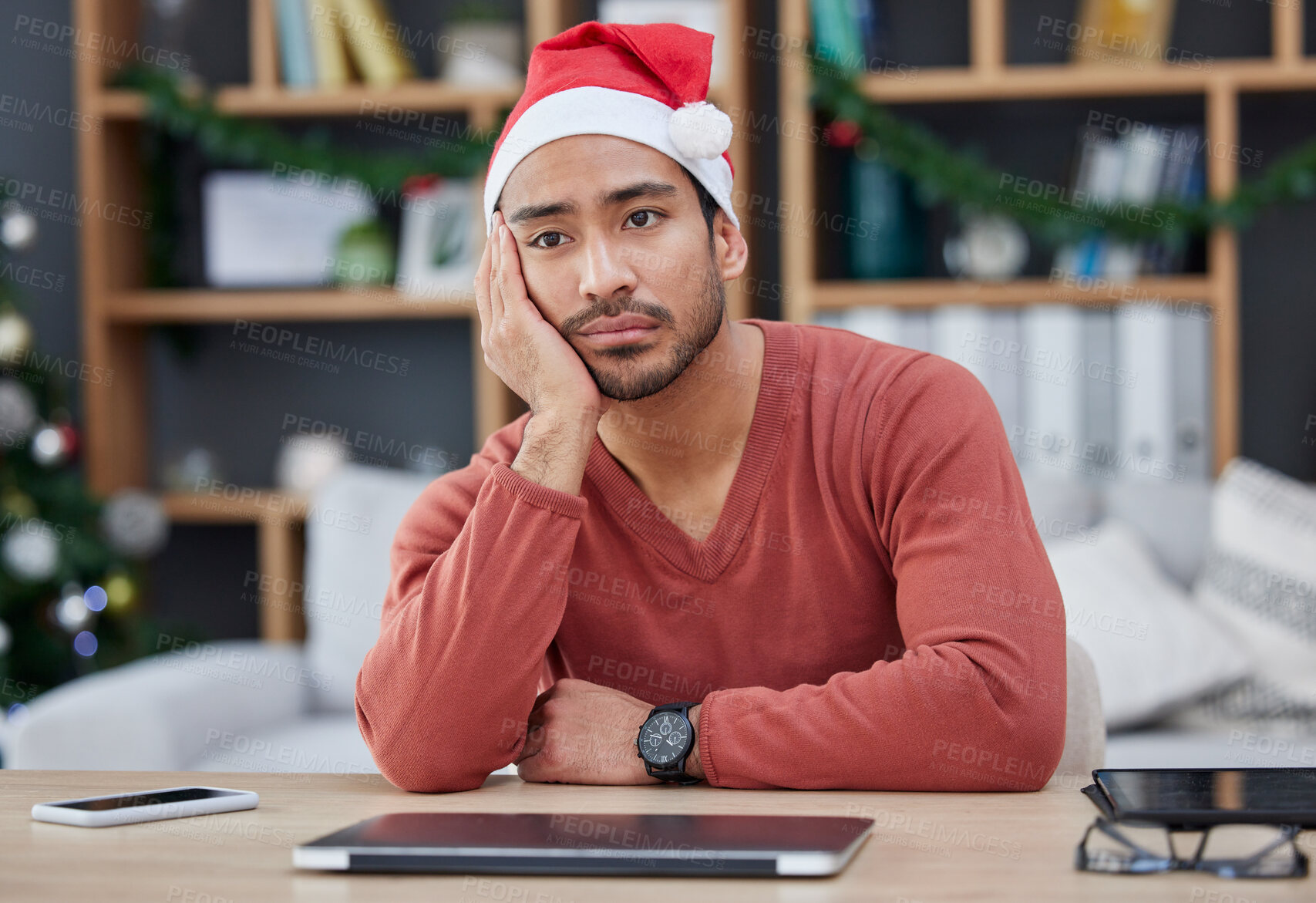 Buy stock photo Bored, christmas hat and exhausted man in the office while working on a creative project. Tired, burnout and young professional male designer with xmas decorations working in the modern workplace.