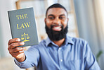 Law, book and happy portrait of a man with the rules or research on legal constitution, regulation or policy from government. African businessman, lawyer or attorney with knowledge of justice