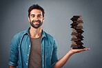 Chocolate, candy and happy with portrait of man in studio for diet, sweets and sugar. Cocoa, food and confectionery with face of person and treat on grey background for unhealthy and snack