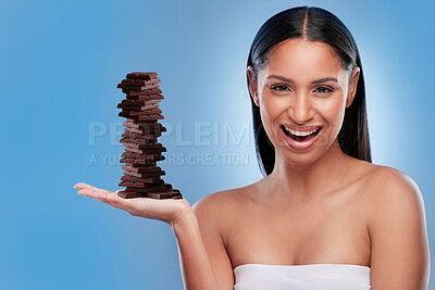 Chocolate, candy and happy with portrait of woman in studio for diet, sweets and sugar. Cocoa, food and confectionery with face of person and treat on blue background for unhealthy and snack