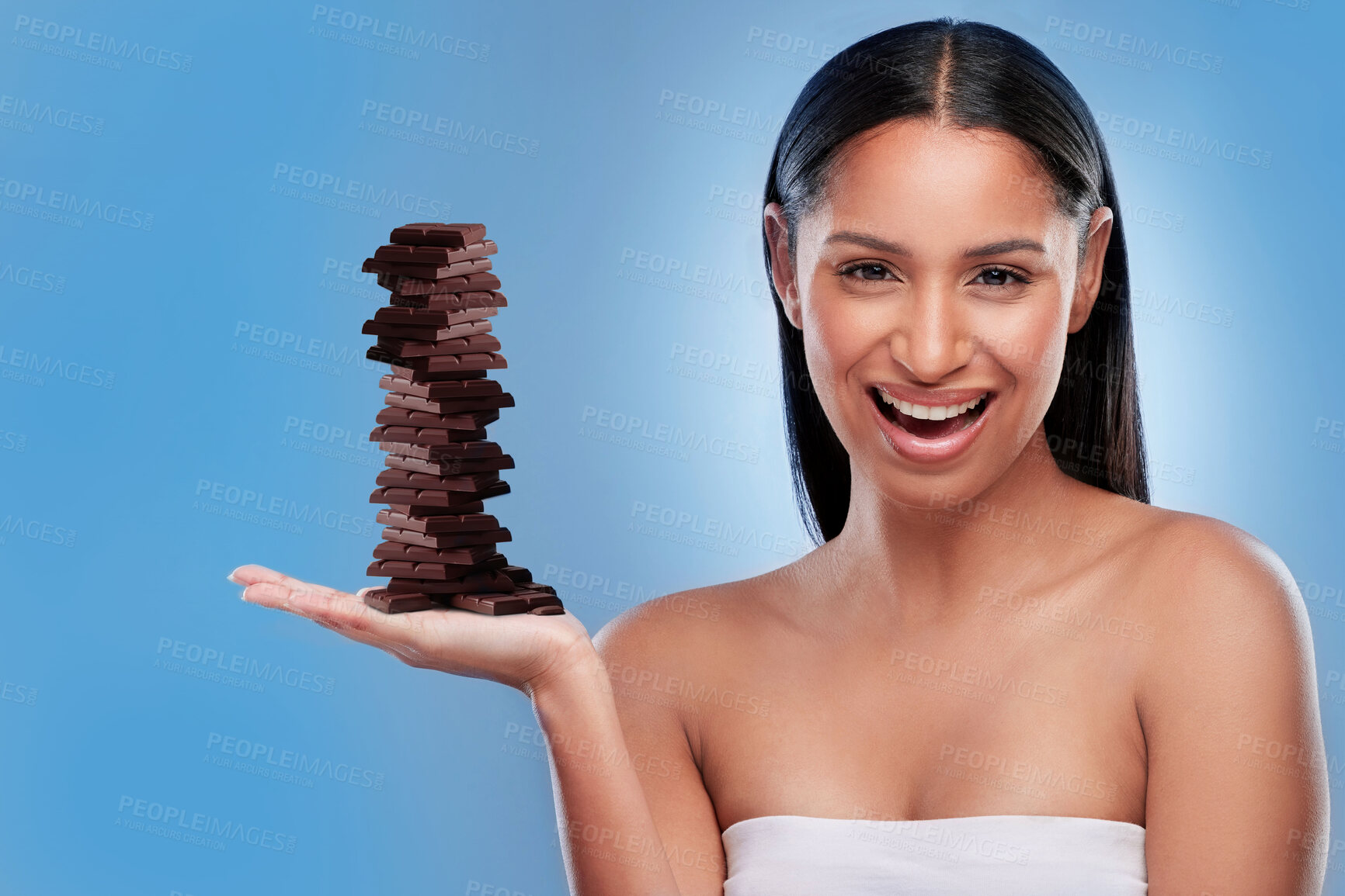Buy stock photo Chocolate, candy and happy with portrait of woman in studio for diet, sweets and sugar. Cocoa, food and confectionery with face of person and treat on blue background for unhealthy and snack