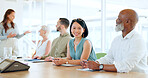 Portrait, meeting and training with a business asian woman sitting in the boardroom during a team seminar. Happy, smile and workshop with a female employee in an office with her colleague group