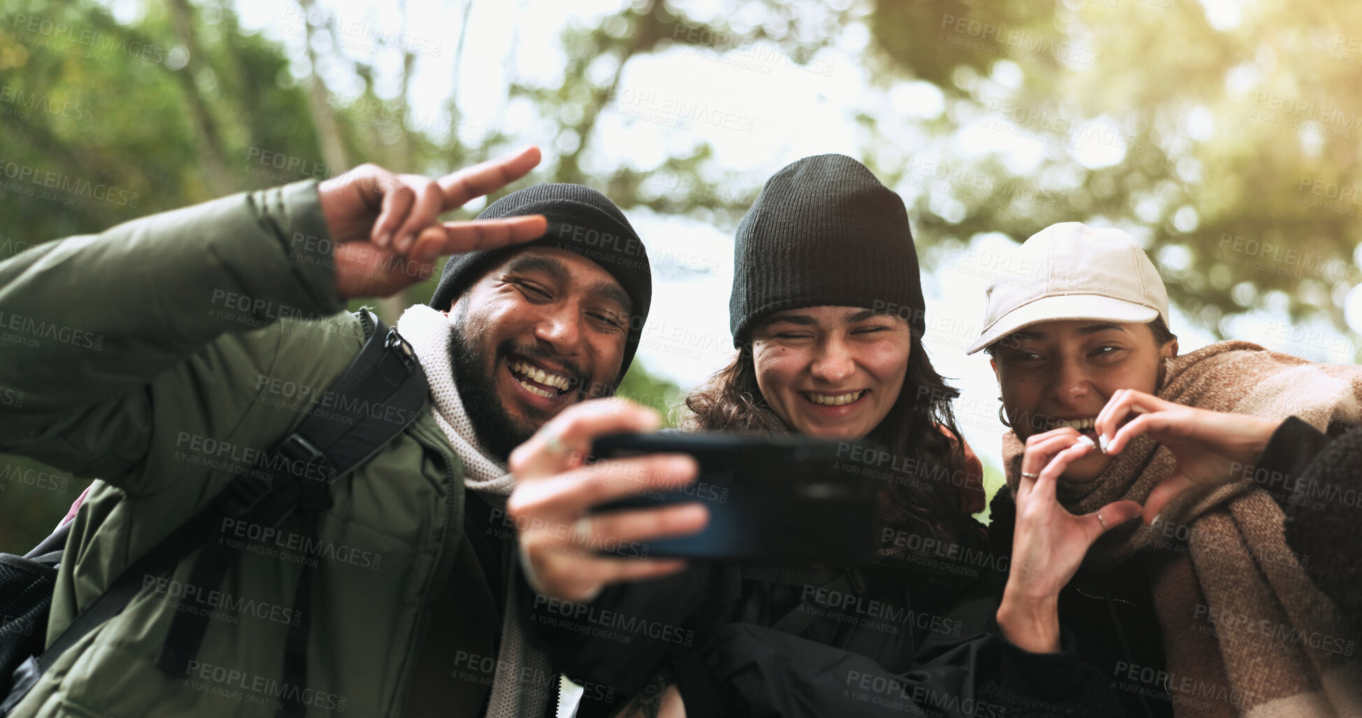 Buy stock photo Friends, hiking and selfie in a forest with peace, heart or hands gesture while bonding in nature. Phone, profile picture and group of people happy in a jungle for adventure, freedom and trekking fun