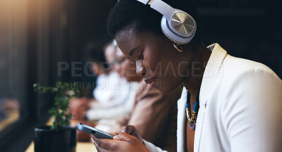 Headphones, phone and woman at cafe listening to music, remote work and networking on social media. African person in workspace, restaurant or coffee shop with mobile chat and audio streaming service