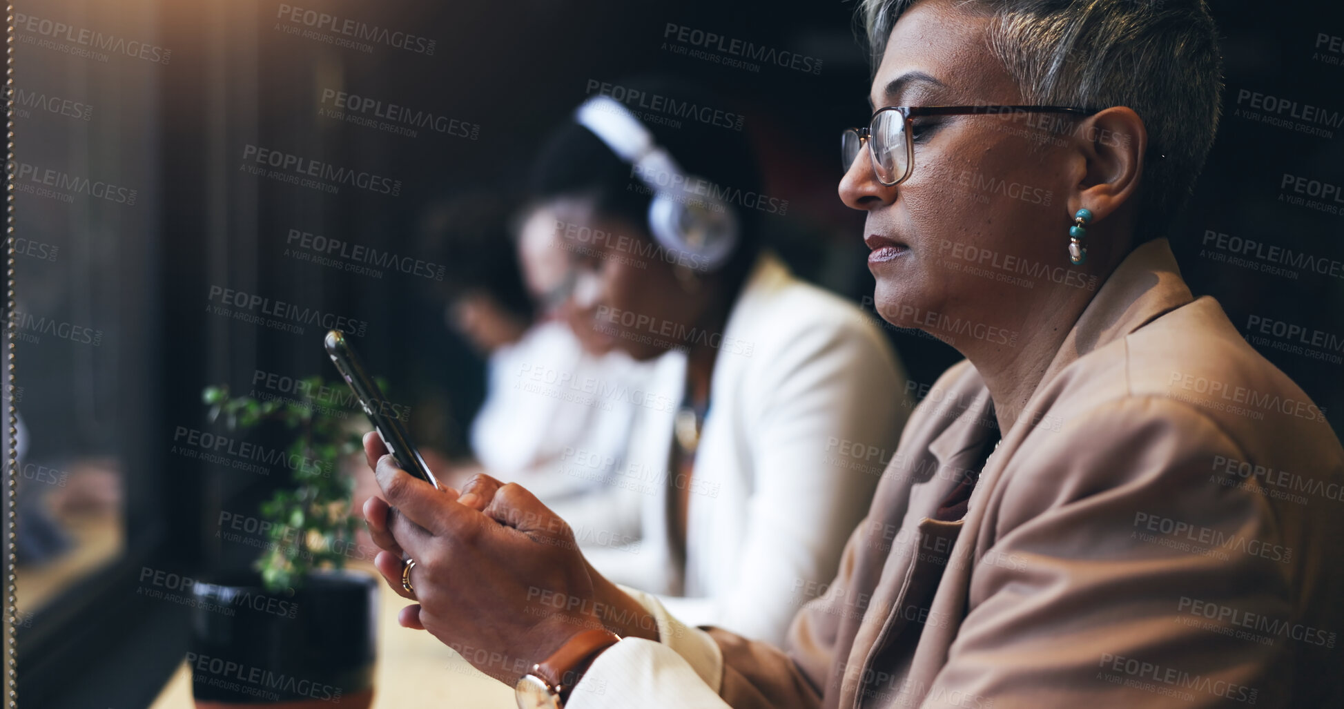 Buy stock photo Face, phone and a business woman in a coffee shop while reading a text message for communication. Mobile, networking and cafe with a mature employee typing in a restaurant for a break from work