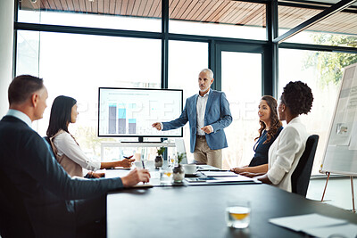 Buy stock photo Businesspeople attending a presentation in the boardroom about growth, innovation and development with graphs in a boardroom. Mature man showing great leadership while talking about company vision