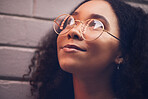 Face, thinking and glasses with a black woman in the city at night against a brick wall closeup for vision. Idea, happy and eyewear with a young female person looking to the future while outdoor