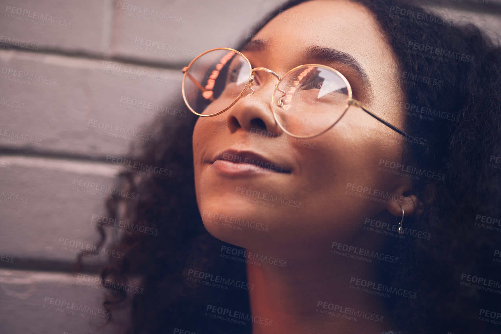 Buy stock photo Face, thinking and glasses with a black woman in the city at night against a brick wall closeup for vision. Idea, happy and eyewear with a young female person looking to the future while outdoor