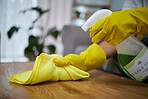 Person, hands and cloth with detergent for cleaning table, housekeeping or germ and bacteria removal at home. Closeup of maid, cleaner or housekeeper wiping wooden desk or furniture for clean hygiene