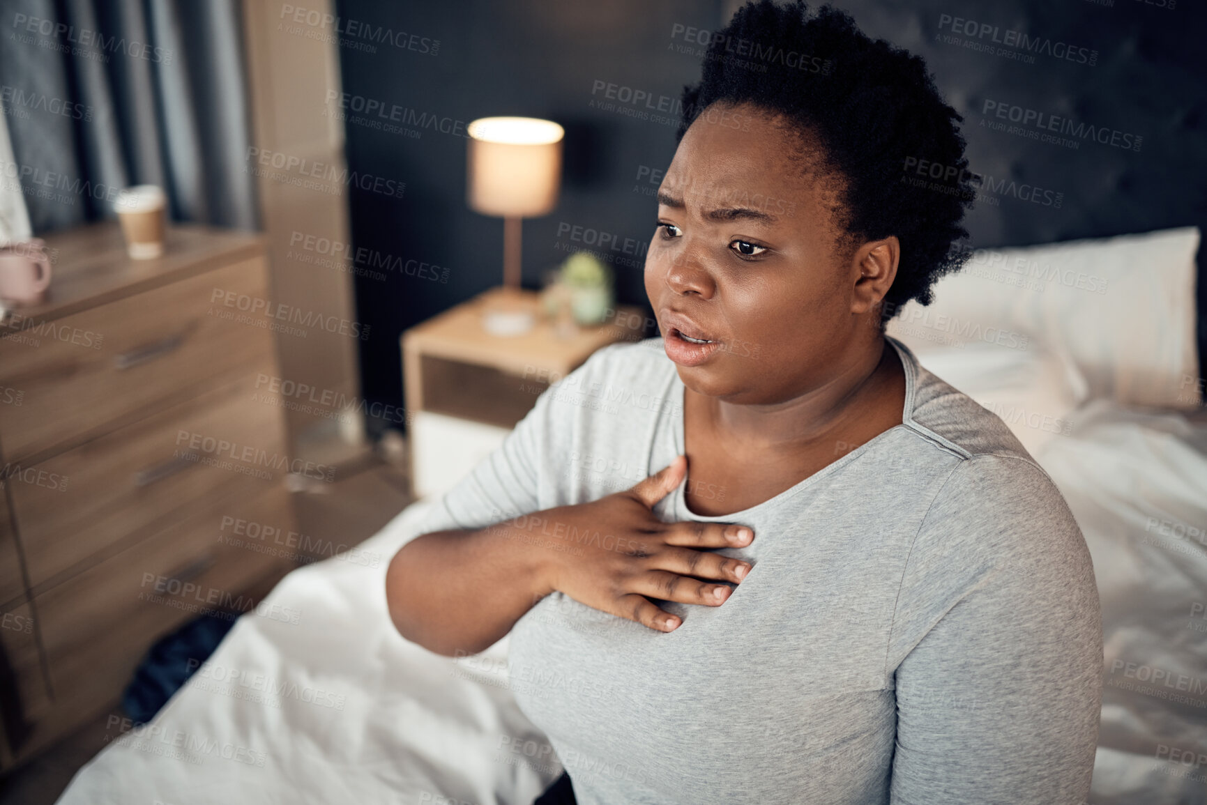 Buy stock photo Fear, bedroom and black woman with an anxiety attack or pain in chest from stress. Scary, health and an African girl on a bed with panic, depression or a mental health, mistake or sick for psychology