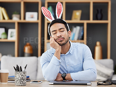 Buy stock photo Tired, sleeping and a man for easter in an office with bunny ears for celebration or bored of a party. Stress, rabbit and a young Asian businessman with fatigue at a work desk with a problem