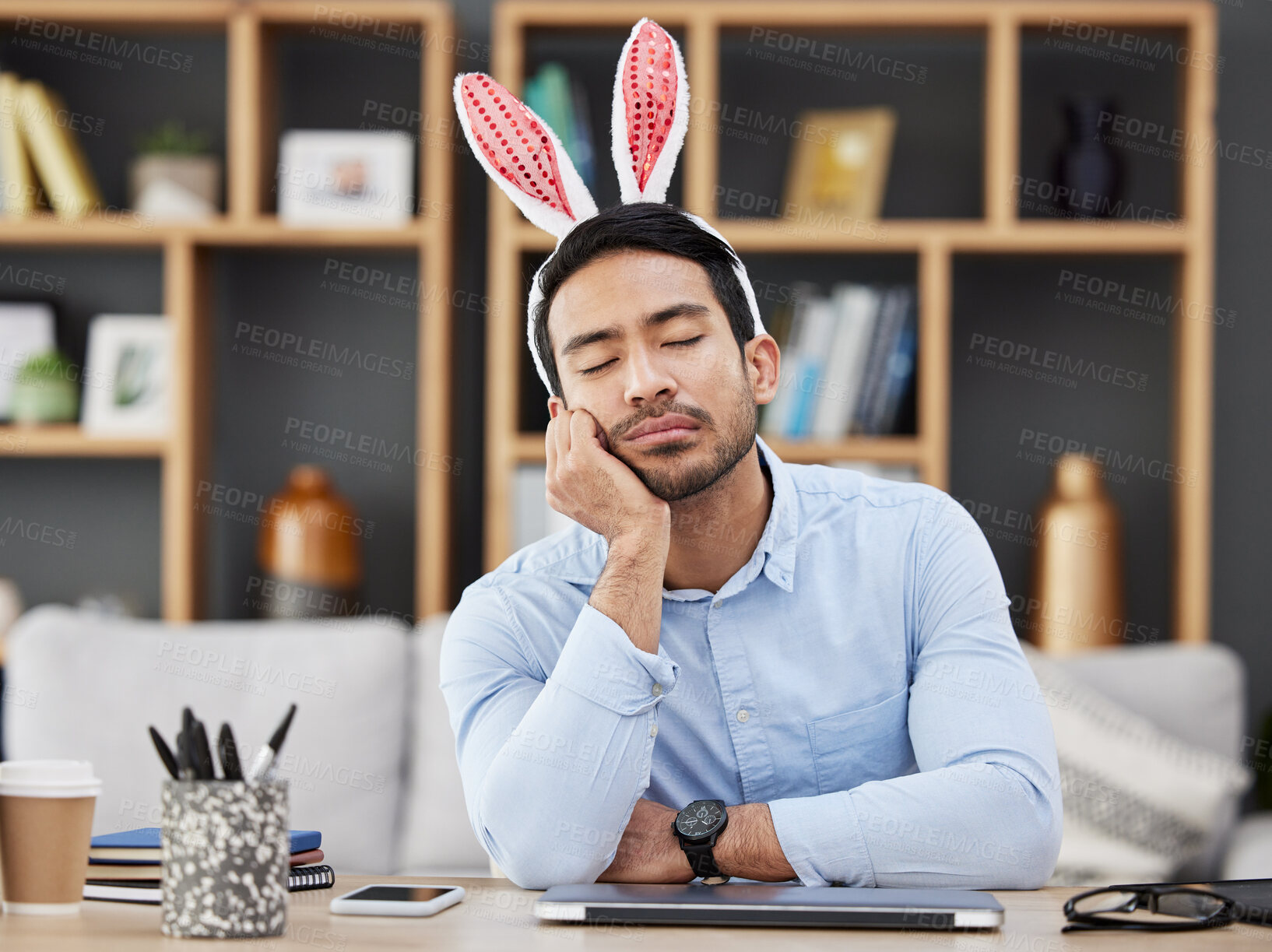 Buy stock photo Tired, sleeping and a man for easter in an office with bunny ears for celebration or bored of a party. Stress, rabbit and a young Asian businessman with fatigue at a work desk with a problem