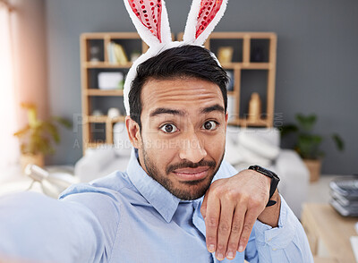 Buy stock photo Bunny ears, holiday and selfie with a man and remote work on easter with creative job. Celebration, happy and male professional from Spain feeling silly and goofy with comedy rabbit hat in a home