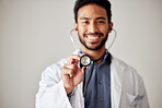 Healthcare, portrait and man doctor hand holding stethoscope in studio for hospital, checkup or exam. face, smile and male cardiovascular expert with medical tool for chest, lungs and heartbeat check