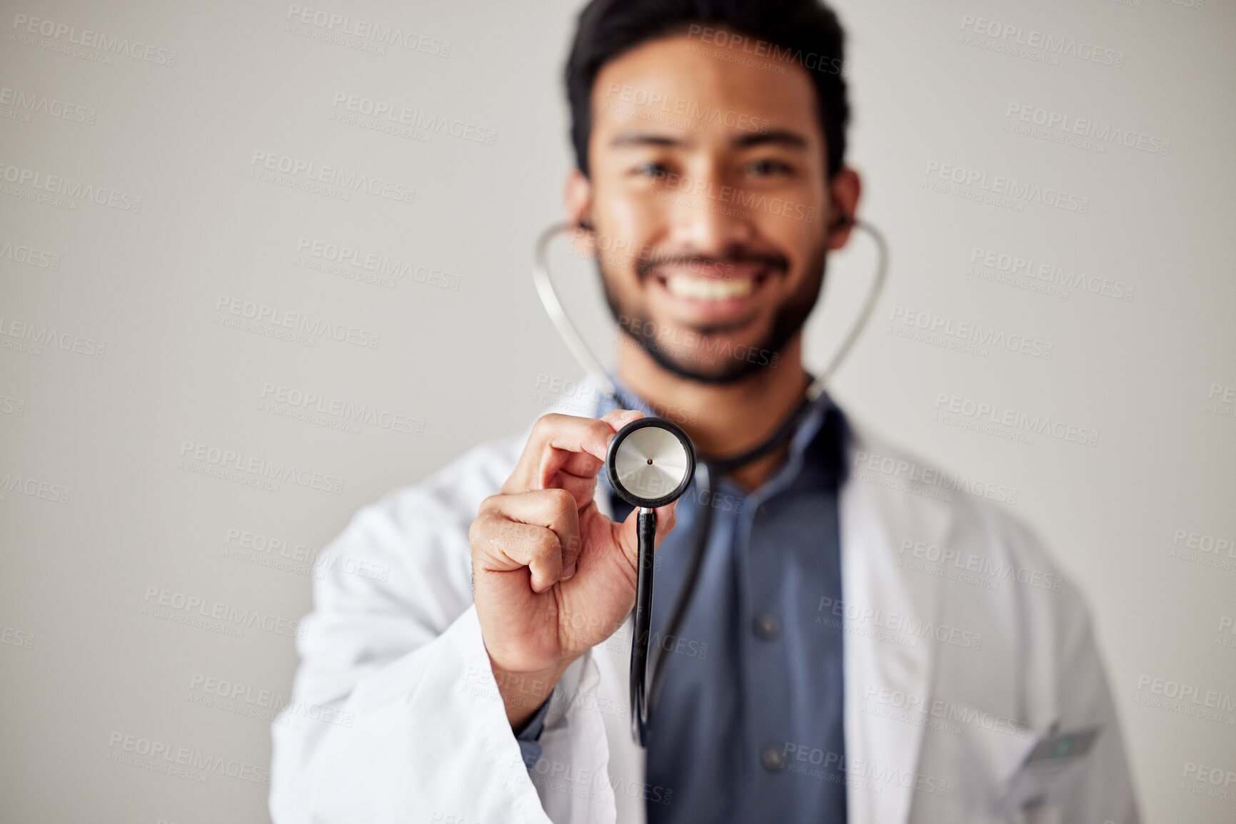 Buy stock photo Healthcare, portrait and man doctor hand holding stethoscope in studio for hospital, checkup or exam. Face, smile and male cardiovascular expert with medical tool for chest, lungs and heartbeat check