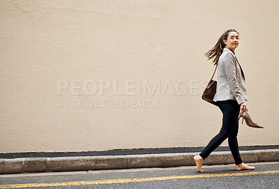 Buy stock photo Woman in street, walking at wall with mockup and barefoot, relax and travel for work holiday in city. Space, road and freedom, person on walk with shoes in hands, morning commute and business trip.