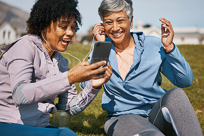 Buy stock photo Senior woman, daughter and outdoor phone call or listening to news, announcement or social media, blog or podcast about workout. Elderly mother, girl and share earphones together on screen