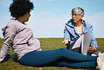 Talking, fitness and senior women friends on the grass outdoor taking a break from their workout routine. Exercise, training and summer with elderly people in conversation on a field for wellness