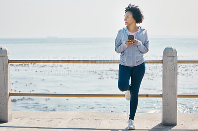 Buy stock photo Relax, phone and fitness with black woman at beach for running, workout and tracking app. Network, communication and contact with female runner training in nature for technology, sports and mobile