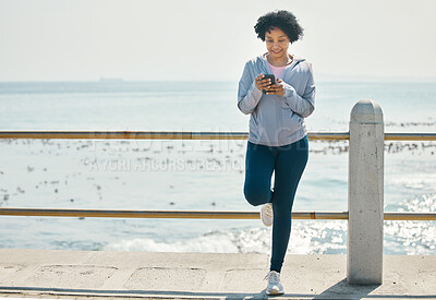 Buy stock photo Fitness, beach and woman with a cellphone, typing and social media with network, sports and smile. Happy person, athlete and seaside with a smartphone, internet connection and contact with exercise