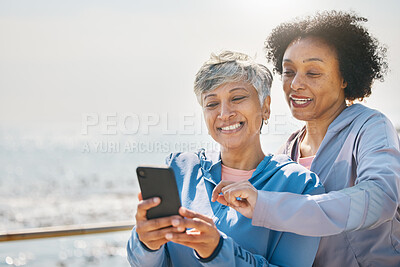 Buy stock photo Senior woman, daughter and reading phone at the beach or social media, blog or post about workout or walk on promenade. Elderly mother, girl and profile picture with water or together on screen