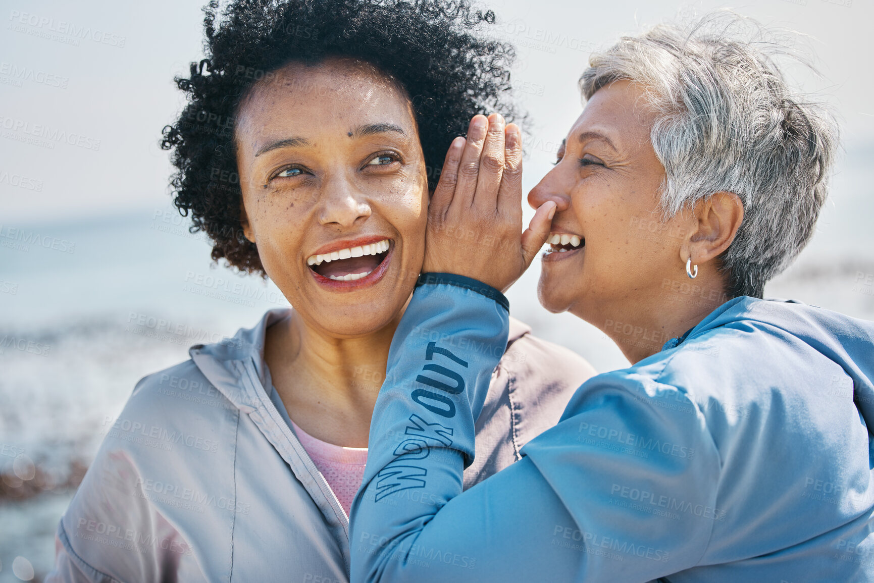 Buy stock photo Gossip, outdoor and senior friends with a secret, whisper or talking in ear for a funny joke after beach exercise. Laughing, crazy and elderly women listening to conversation or story at the sea