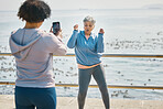 Senior woman, dancing and influencer outdoor for fitness, fun energy and celebrate retirement. Exercise, mature and funny people at sea for happy photograph, adventure or social media travel memory
