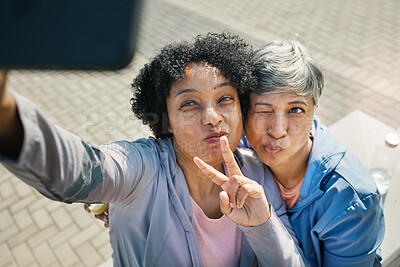 Buy stock photo Senior women, selfie and peace, hands and wink in a city for travel, fun and chilling on the weekend outdoor. Face, friends and old ladies pose for profile picture, photo or traveling memory in town