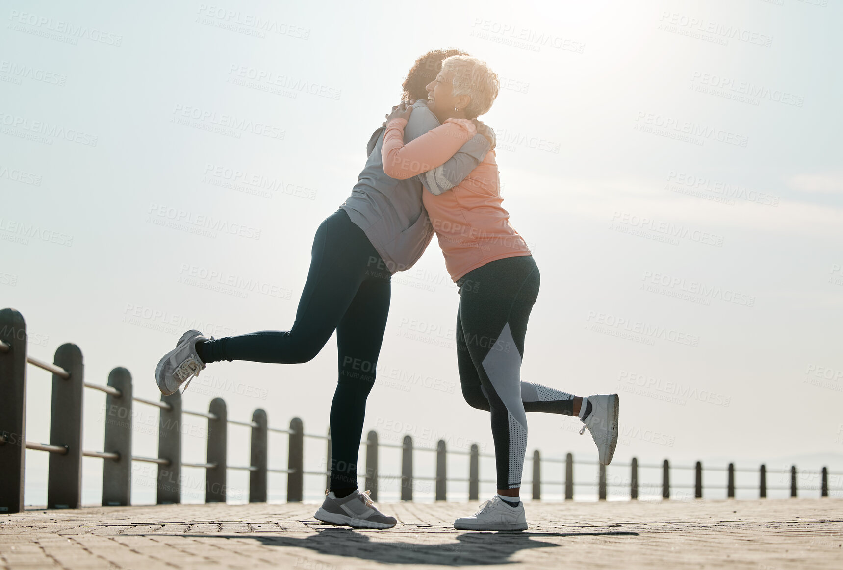 Buy stock photo Running, hug and women by sea and ocean with love and care for fitness and exercise. Athlete, wellness and female friends on a beach promenade with motivation, embrace and smile from runner target