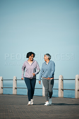 Buy stock photo Exercise, walking and senior women by ocean for healthy body, wellness and cardio on promenade. Sports, friends and happy female people in conversation on boardwalk for fitness, training and workout