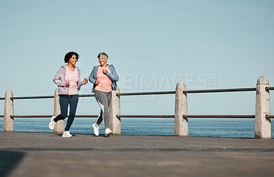 Buy stock photo Senior women, fitness and running at beach for health, wellness and exercise in nature together. Elderly, friends and ladies at sea talking, workout and active retirement, fun and bonding ocean run