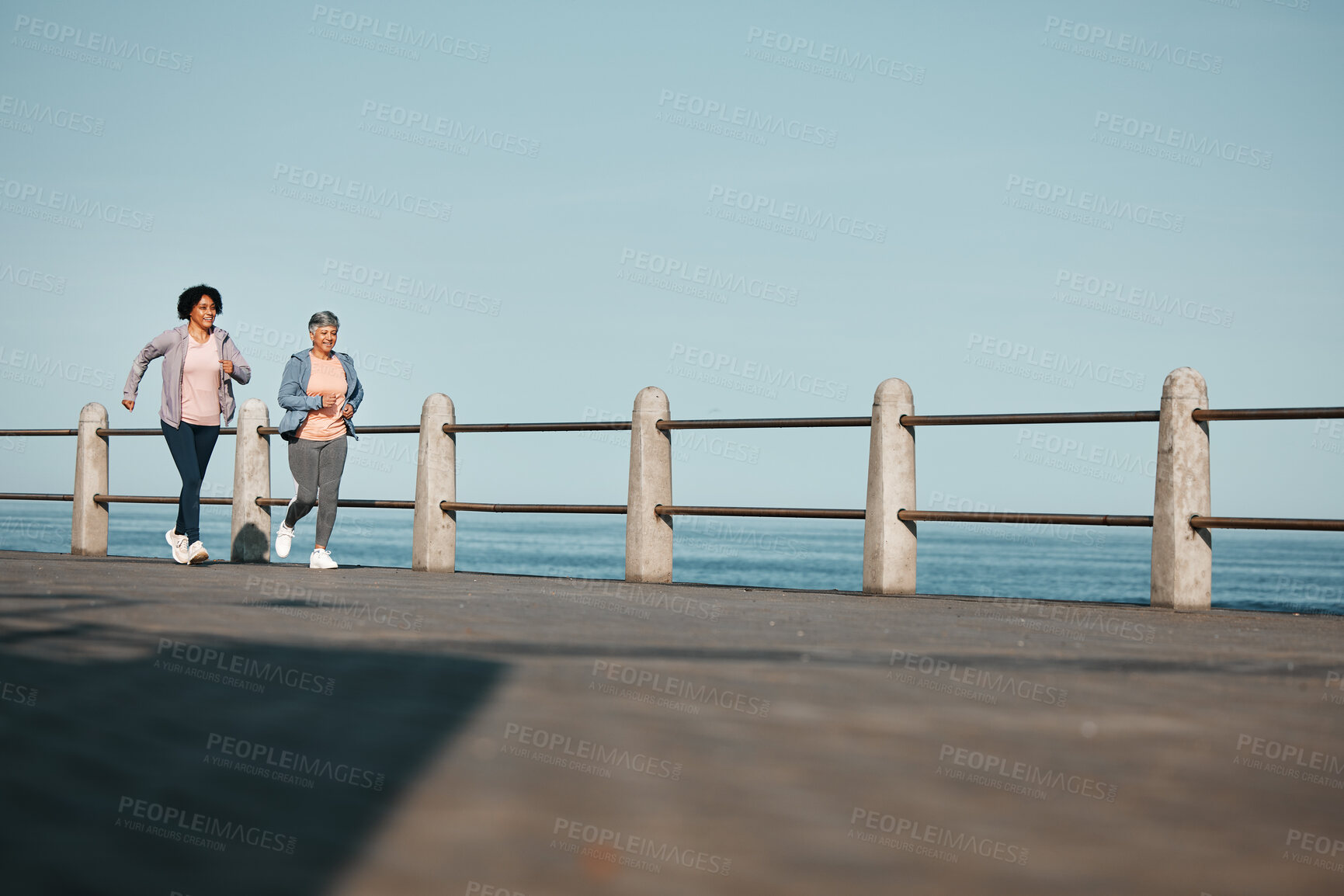 Buy stock photo Fitness, friends and senior women at the beach for exercise, health or cardio on blue sky background. Training, wellness and elderly lady runner at the sea for morning workout, routine or ocean run
