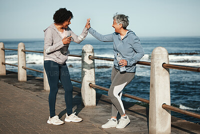 Buy stock photo Fitness, high five and senior women by ocean for healthy lifestyle, wellness and cardio on promenade. Sports, friends and female people celebrate on boardwalk for exercise, training and workout goals