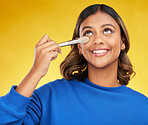 Woman, makeup and brush with skincare, luxury and beauty on a yellow studio background. Female person, smile or model with cosmetic tool, wellness or foundation with self care, aesthetic or eyeshadow