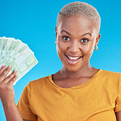 Black woman, pointing at cash fan and surprise with finance, payment and  lottery win isolated on blue background. Female person with wow face, money  and financial freedom, dollar bills in a studio
