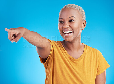 Buy stock photo Pointing, smile and black woman with advertising space, happiness and announcement on a blue studio background. Happy girl, female person and model with gesture, direction and choice with a decision