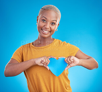 Buy stock photo Portrait, love and heart with a black woman on blue background in studio for health or wellness. Smile, emoji and social media with a happy young person looking excited for romance or valentines day