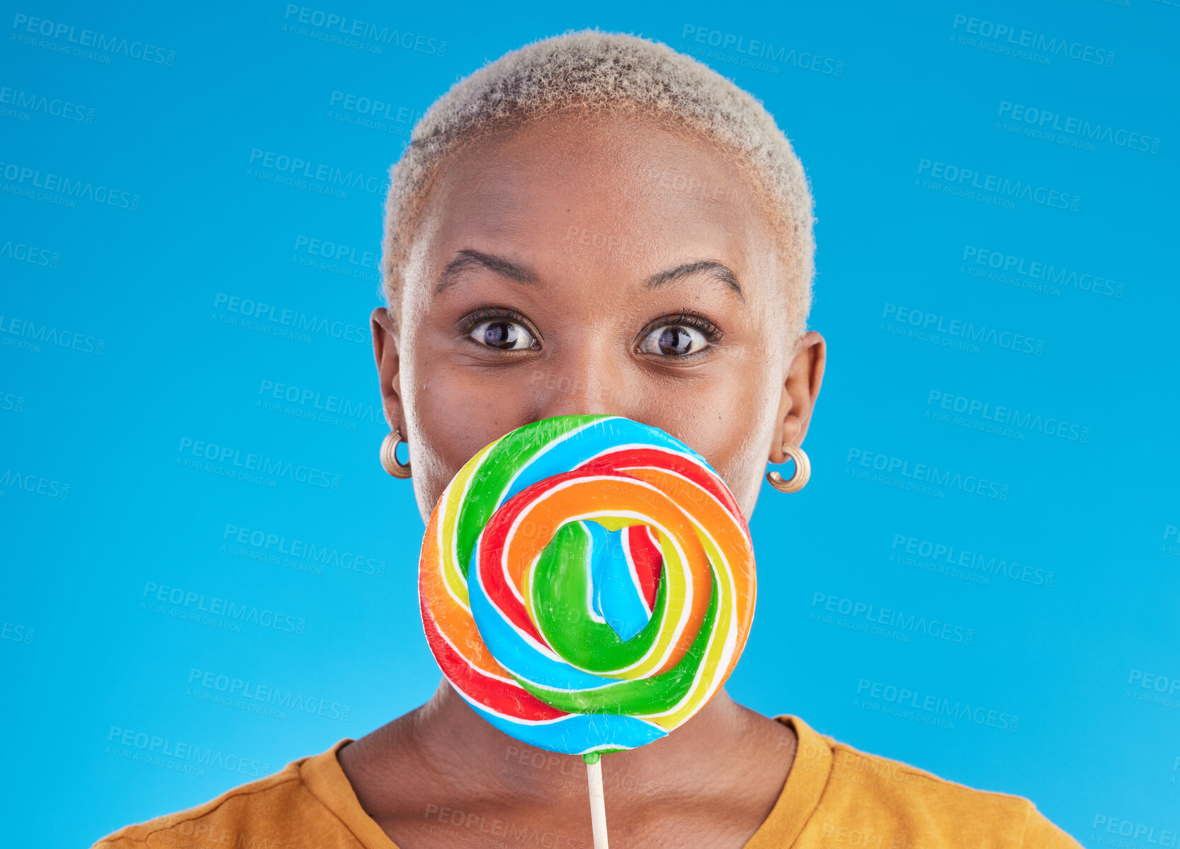 Buy stock photo Candy, lollipop and portrait a woman in studio for wow sweets, rainbow and creative advertising. Happy black female person isolated on a blue background with sugar, freedom and color surprise
