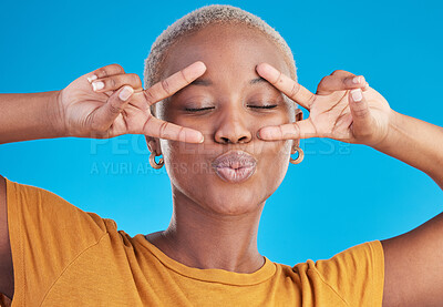 Buy stock photo Kiss, black woman and peace hands on face in studio for self love, thank you or good vibes on blue background. V, sign and African female with cool mood, pose or freedom emoji for support or swag
