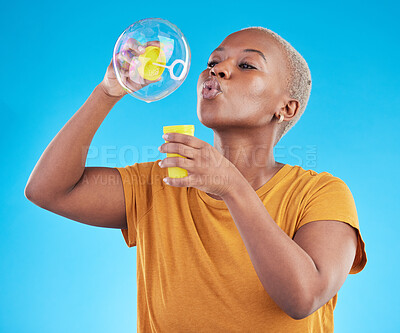Buy stock photo African, woman and blowing bubbles in studio, blue background or party celebration with fun, liquid soap or toy. Black model, person and relax with happy, joyful or creative play for enjoyment