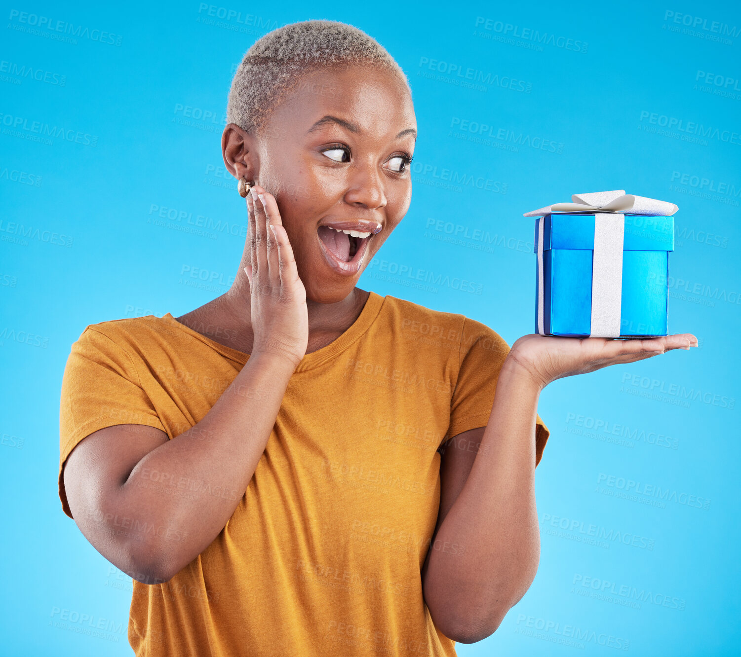 Buy stock photo Wow, gift and excited black woman with box in studio isolated on a blue background. Surprise, happy and African person with present for party, celebration of holiday or birthday package for giveaway