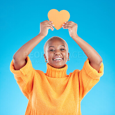 Buy stock photo Portrait, emoji and heart with a black woman on blue background in studio for health or wellness. Smile, love and social media with a happy young person looking excited for romance or valentines day