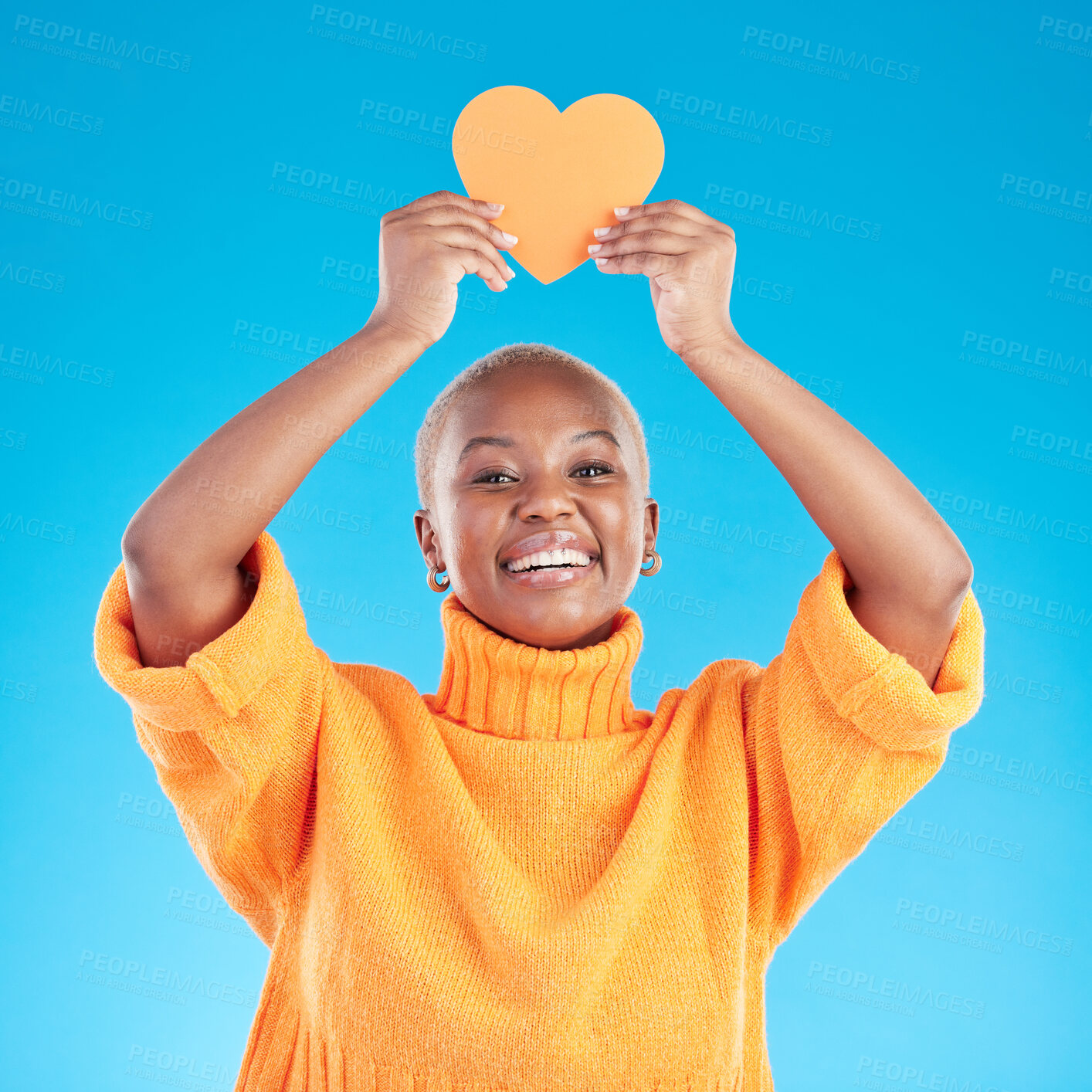 Buy stock photo Portrait, emoji and heart with a black woman on blue background in studio for health or wellness. Smile, love and social media with a happy young person looking excited for romance or valentines day