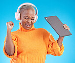 Winner, success or black woman in studio with tablet, achievement or bonus on blue background. Headphones, giveaway or happy person with technology in celebration of reward, prize or online victory
