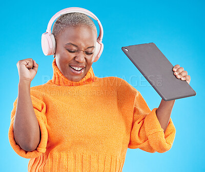 Buy stock photo Winner, success or black woman in studio with tablet, achievement or bonus on blue background. Headphones, giveaway or happy person with technology in celebration of reward, prize or online victory