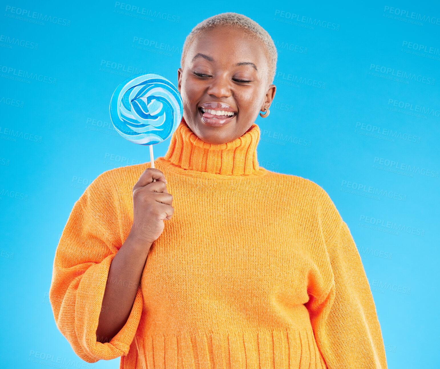 Buy stock photo Smile, lollipop and black woman with candy in studio isolated on a blue background. African person, happy and tongue out for sweets, dessert and treats, sugar food and confectionary for eating
